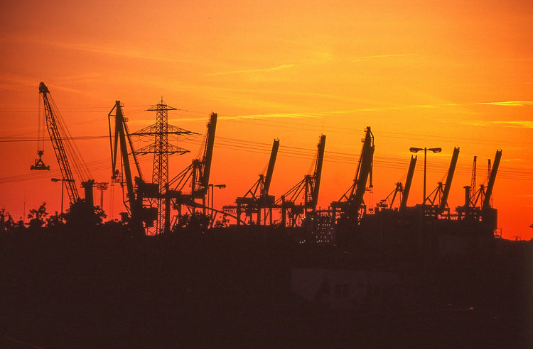 Silhouetten von Industriekränen im Hamburger Hafen zum Sonnenuntergang