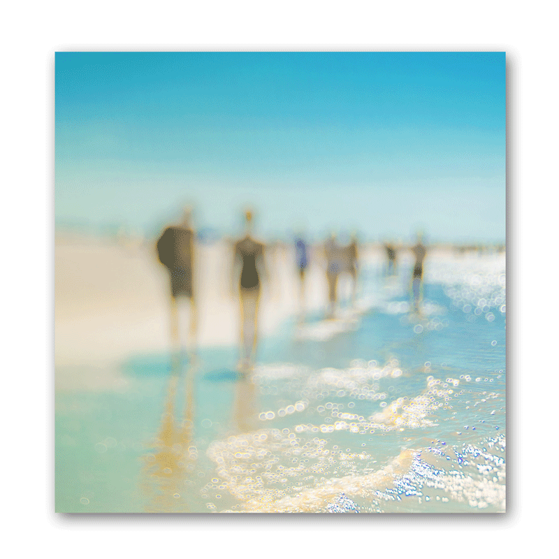 Farbige Silhouetten von Menschen am Strand im Sommer, die durch das Wasser am Strand laufen