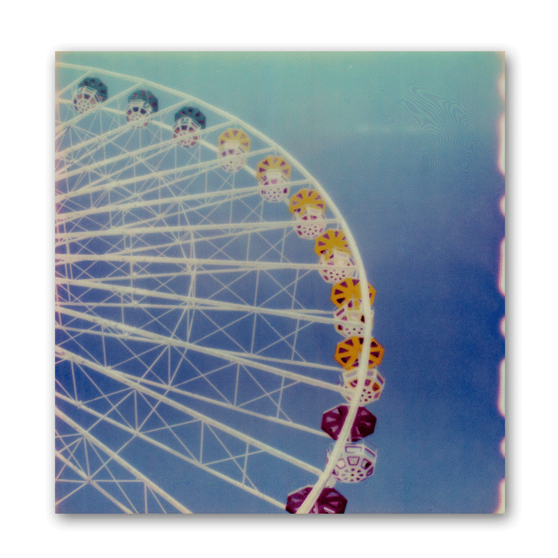 Polaroid-Foto eines Riesenrads vor blauem Himmel