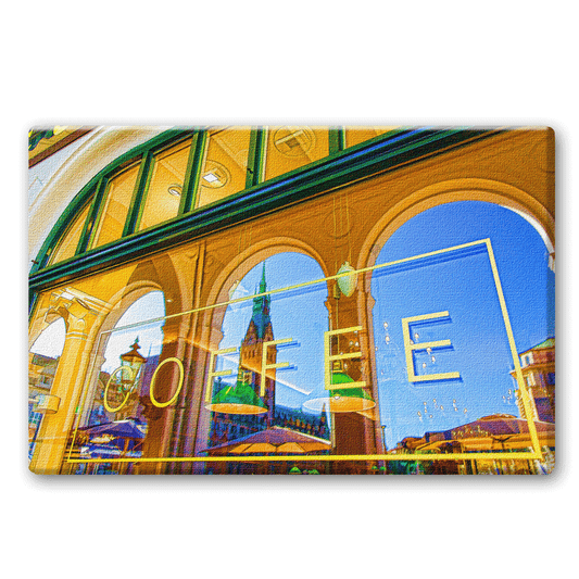 Das Hamburger Rathaus spiegelt sich in einem Café an den Alsterarkaden.