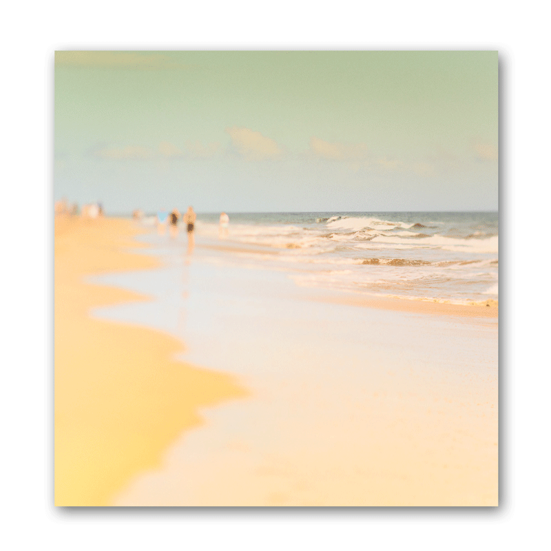 Menschen laufen am Meer im seichten Wasser am Strand entlang