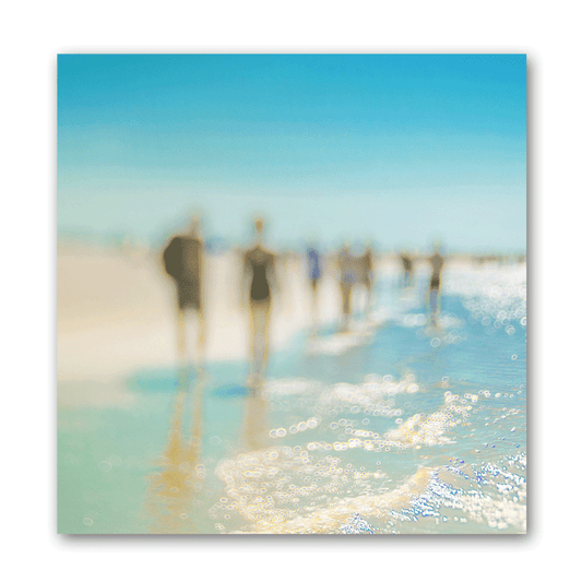Farbige Silhouetten von Menschen am Strand im Sommer, die durch das Wasser am Strand laufen