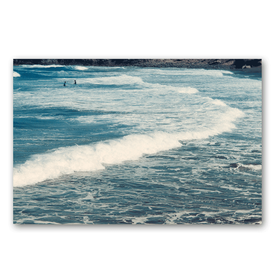 Zwei Surfen warten im Meer auf die nächste Welle.