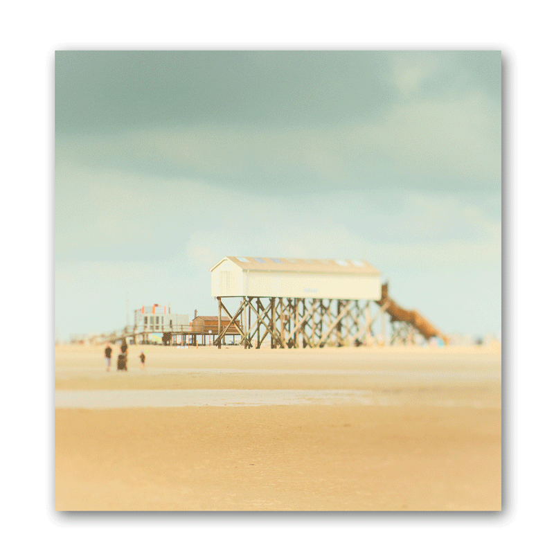Ein Stelzenhaus mit Holzstelzen am flachen Strand in Sankt Peter-Ording